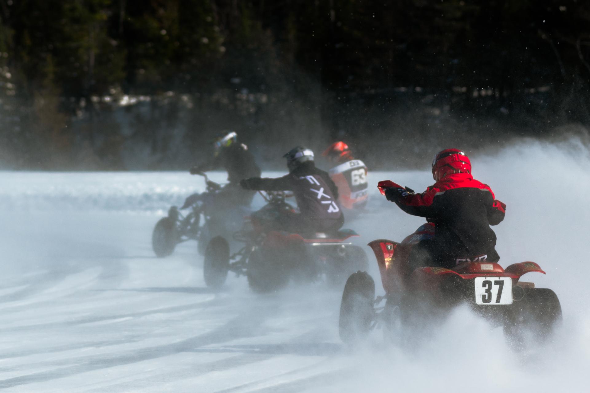 A dynamic image featuring four ATVs participating in exhilarating ice racing.