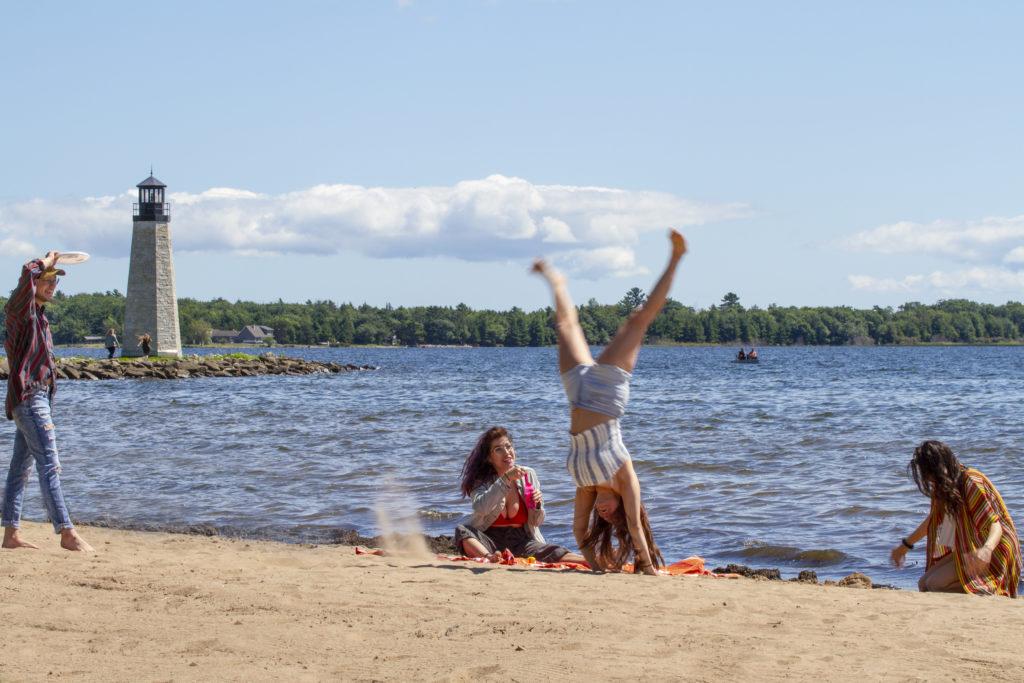 young woman doing a cartwheel on the beach