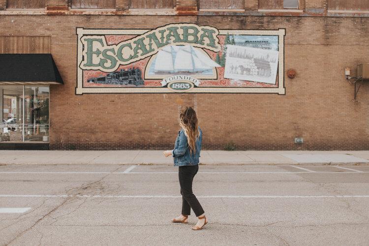 woman standing near a wall mural