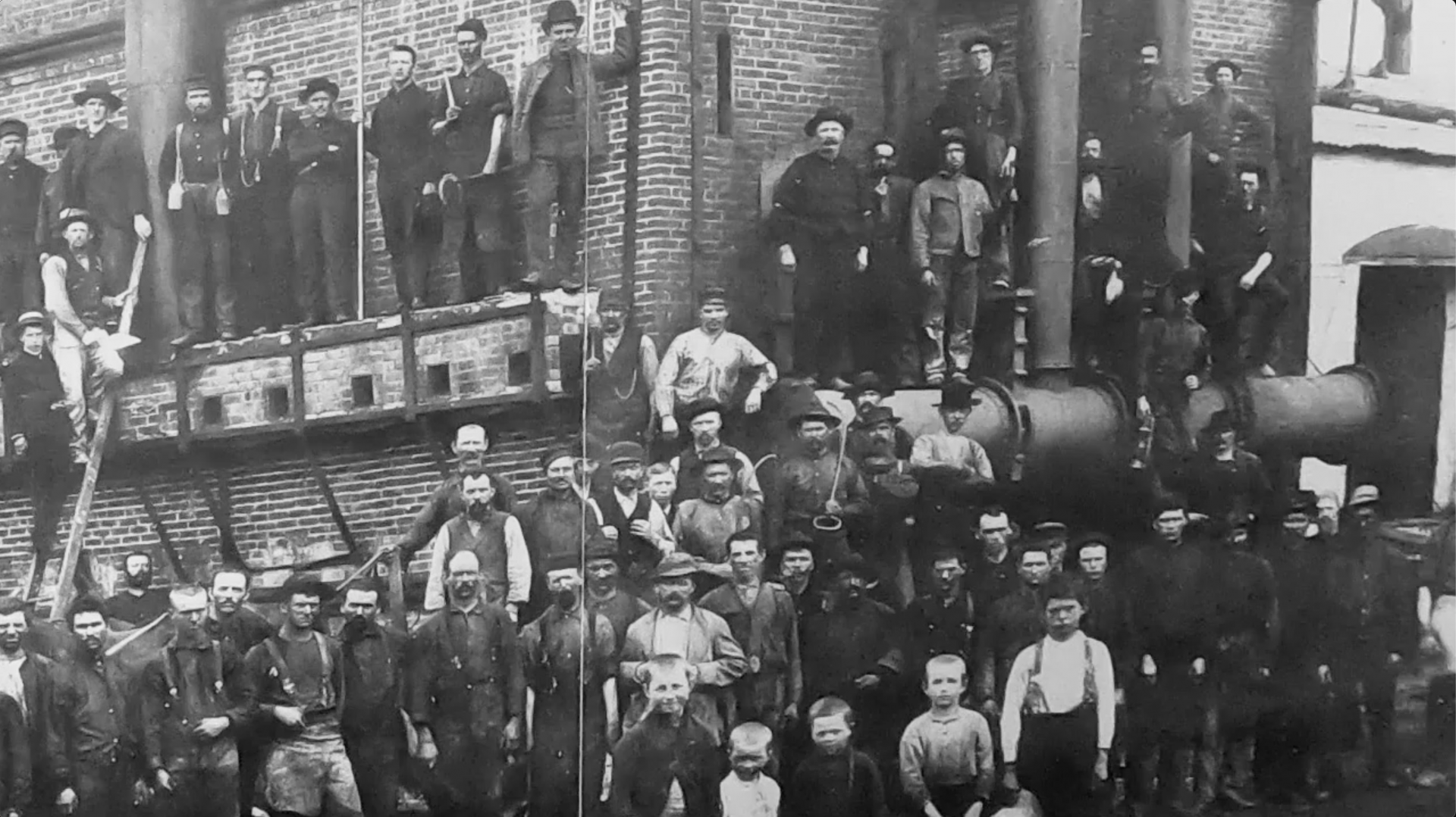 old photo of workmen standing outside a factory
