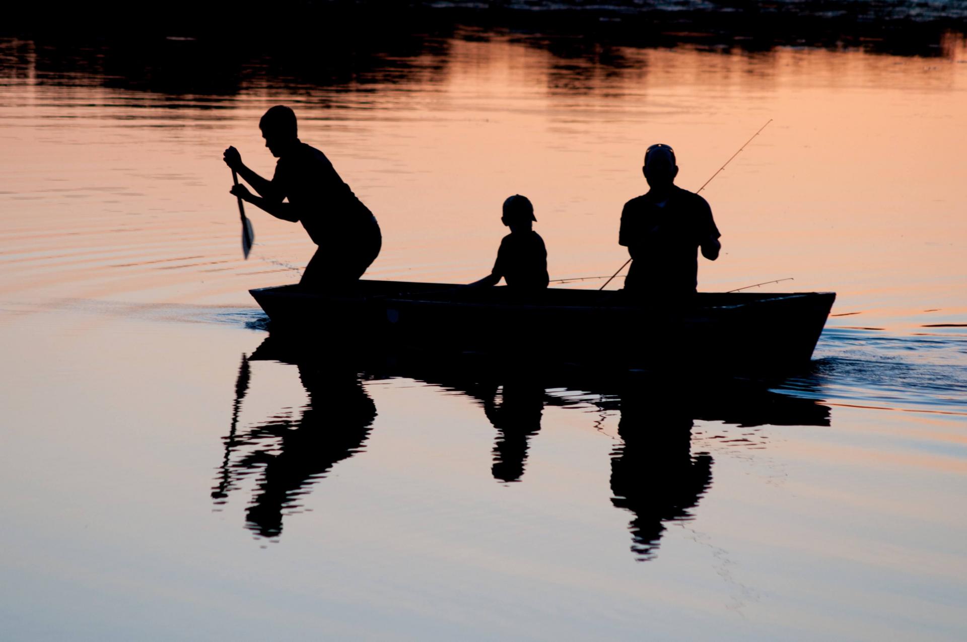 three people on boat fishing in late fall